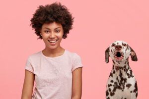 Cheerful African American female being in love with her dalmatian